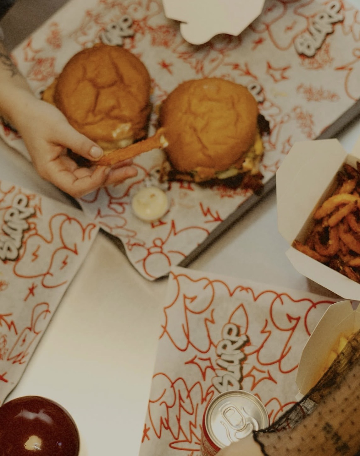 Tavolo SLURP con burger, patatine e carta oleata